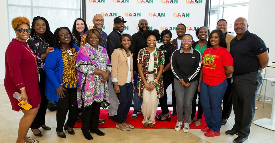 A large group photo taken in front of a GAAN back drop 