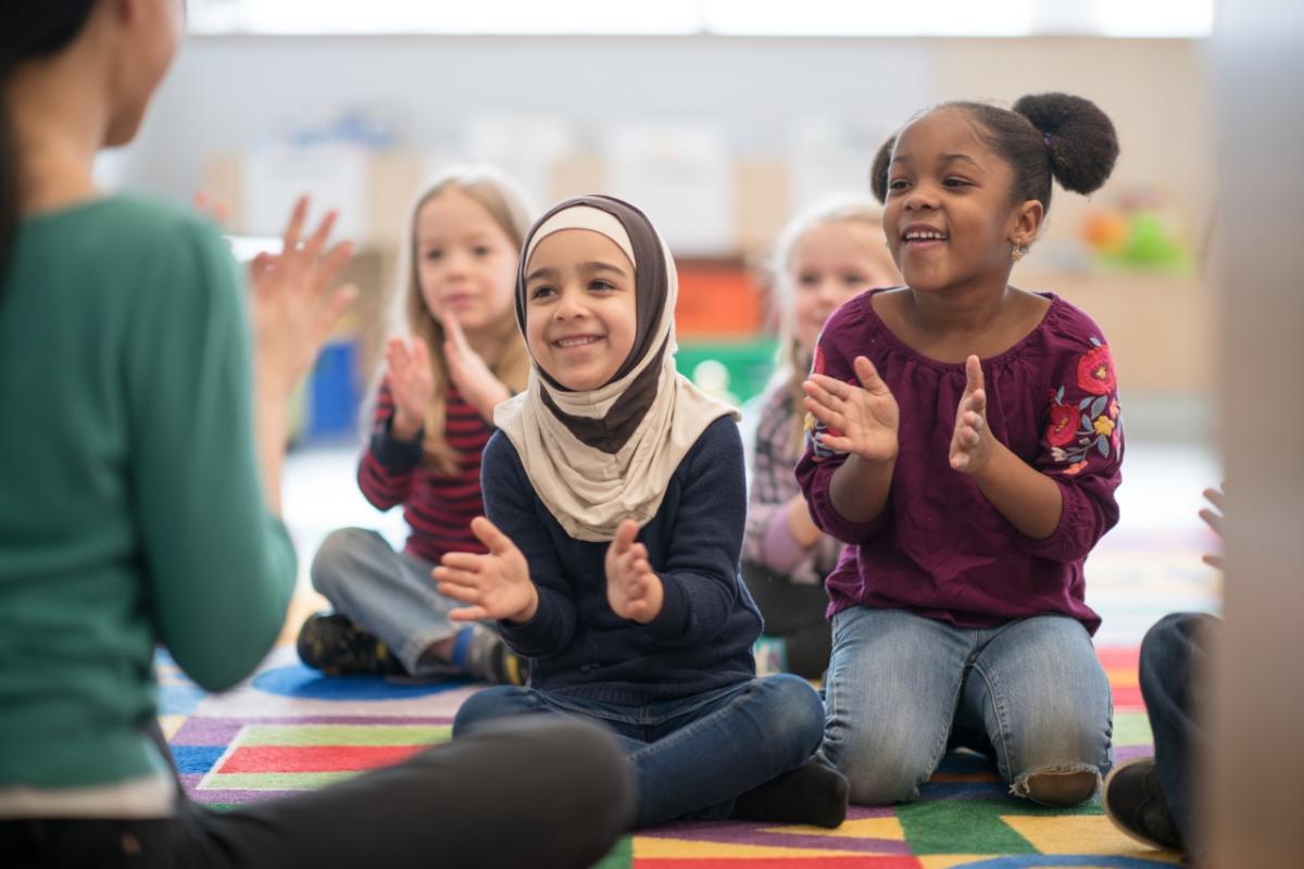 children sitting down clapping their hands