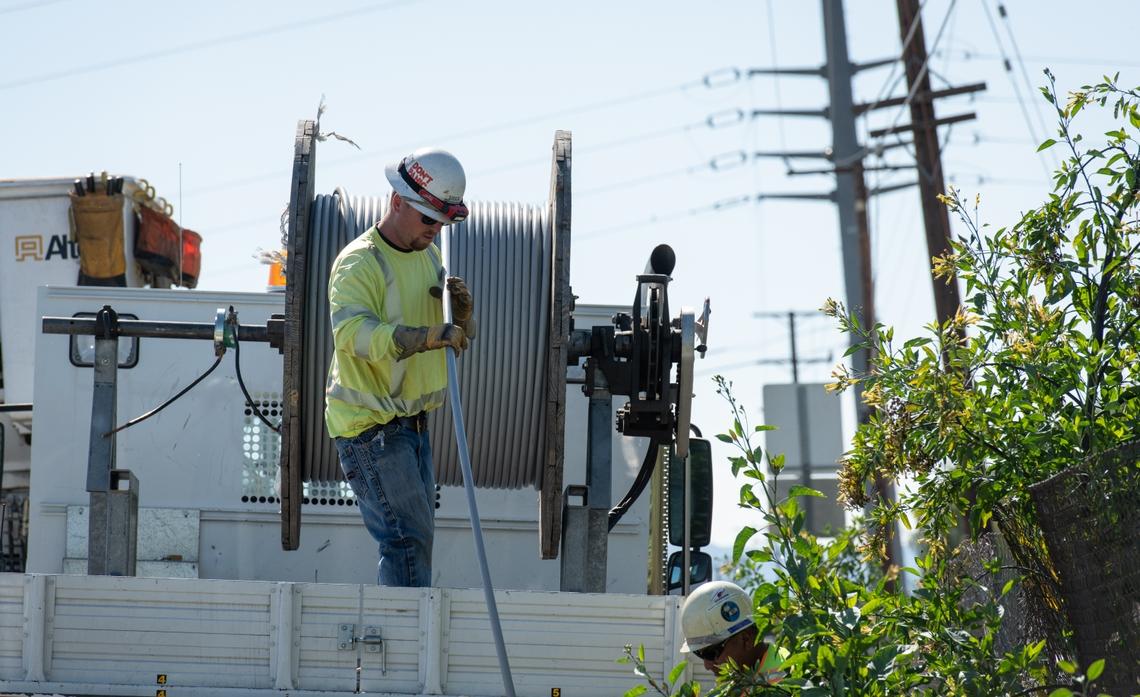 Employees installing wire covered with a protective coating