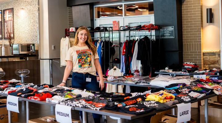 Emily standing with different clothing items