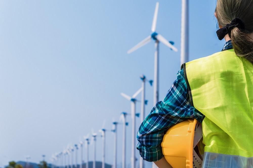 person in foreground with windmills in background