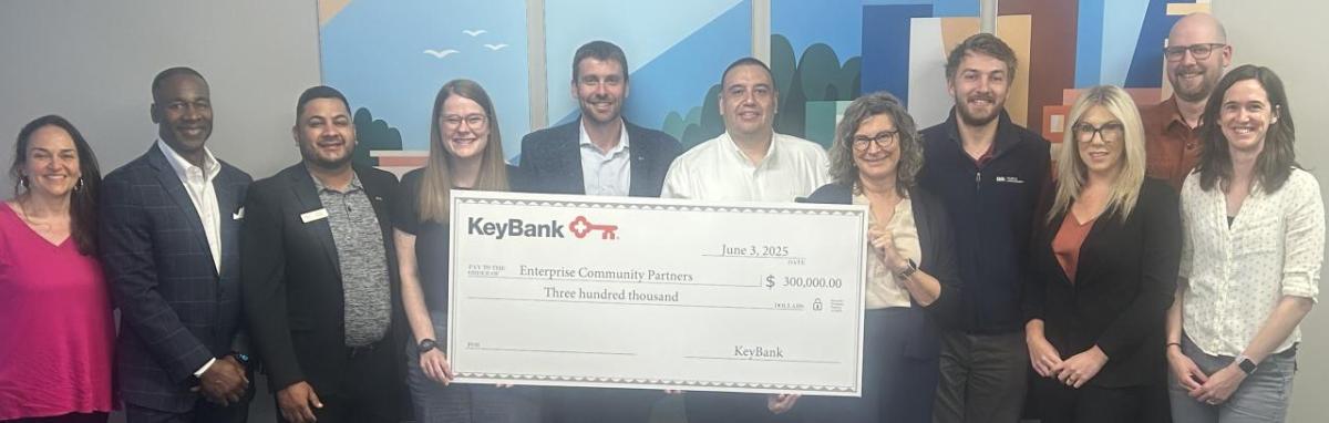Representatives from KeyBank and Enterprise Community Partners shown with a grant check for $300,000.