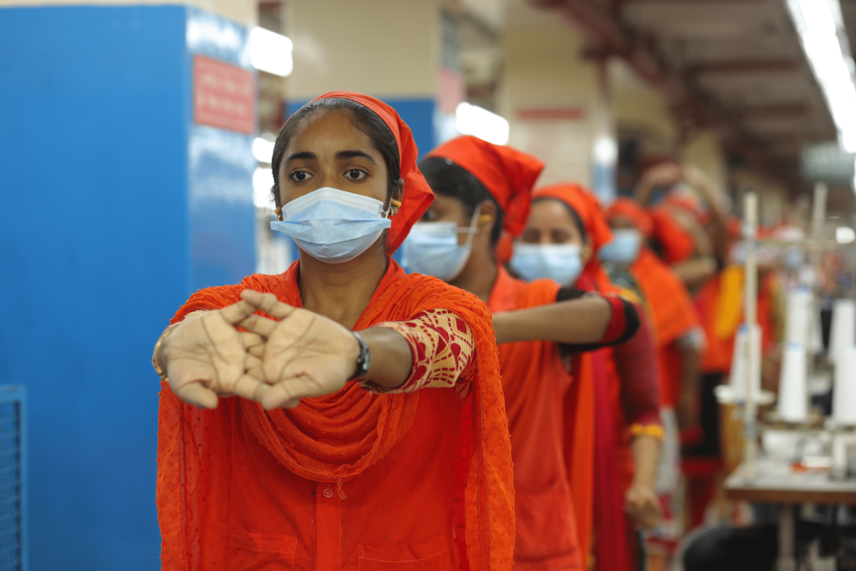 Sewing operators stretching during an ergonomic pause in Gildan's facility