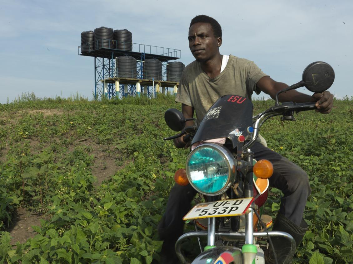 Ernest sitting on his motorized bike in front of his garden.