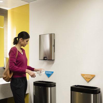 Woman disposing of a hand towel.