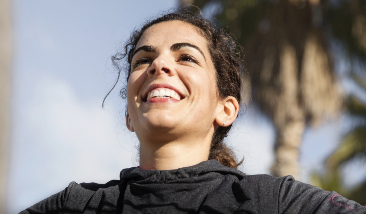 Young woman smiling with her arms outstretched.