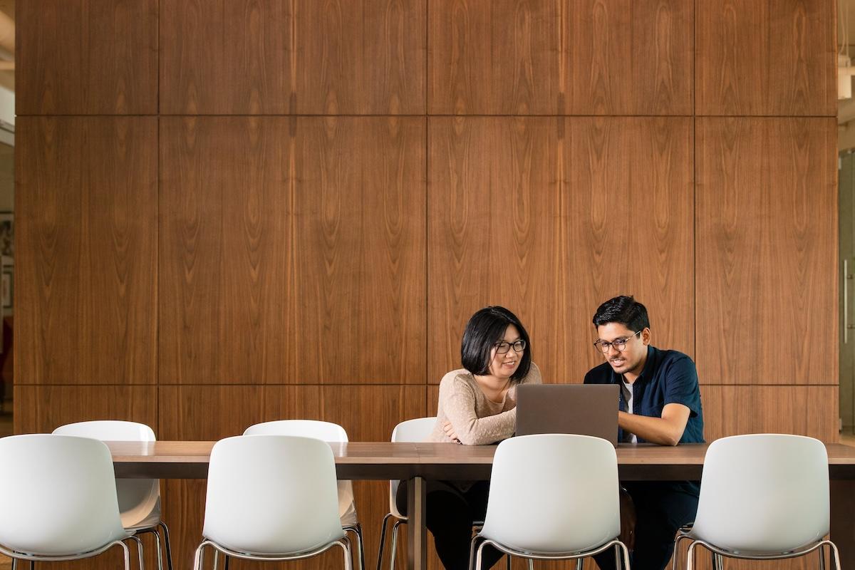 Two GoDaddy employees seated at a conference table.