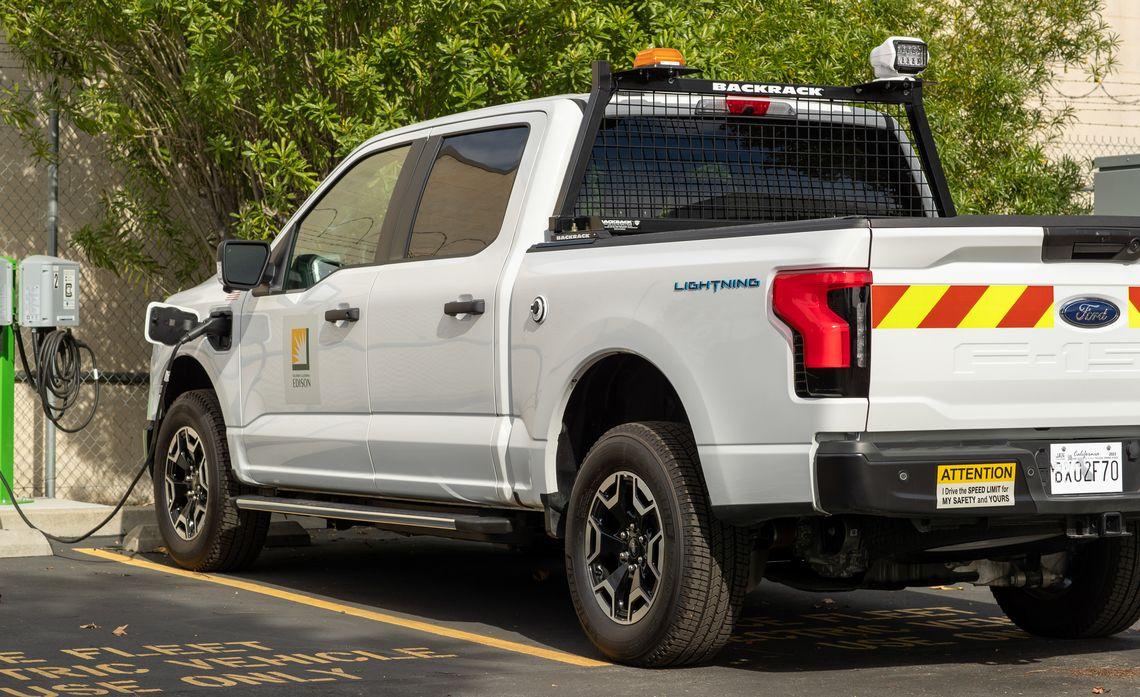 A Ford F150 truck plugged in to a charging station.