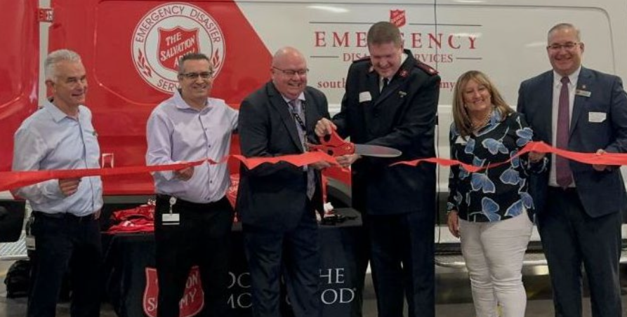 FedEx volunteer assists with ribbon cutting event marking the donation of a mobile canteen by FedEx