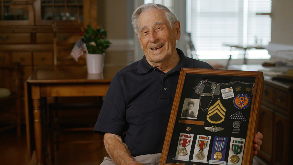 Frank Perry Holding a box of displayed awards.