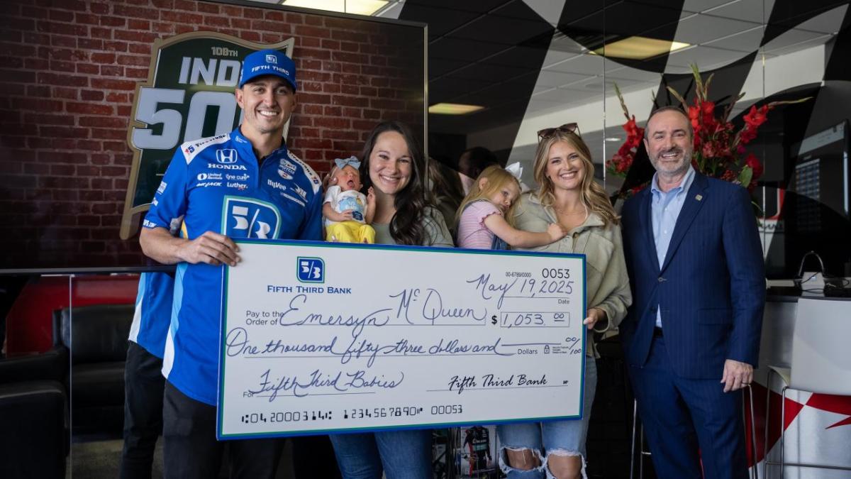 Family poses with large check