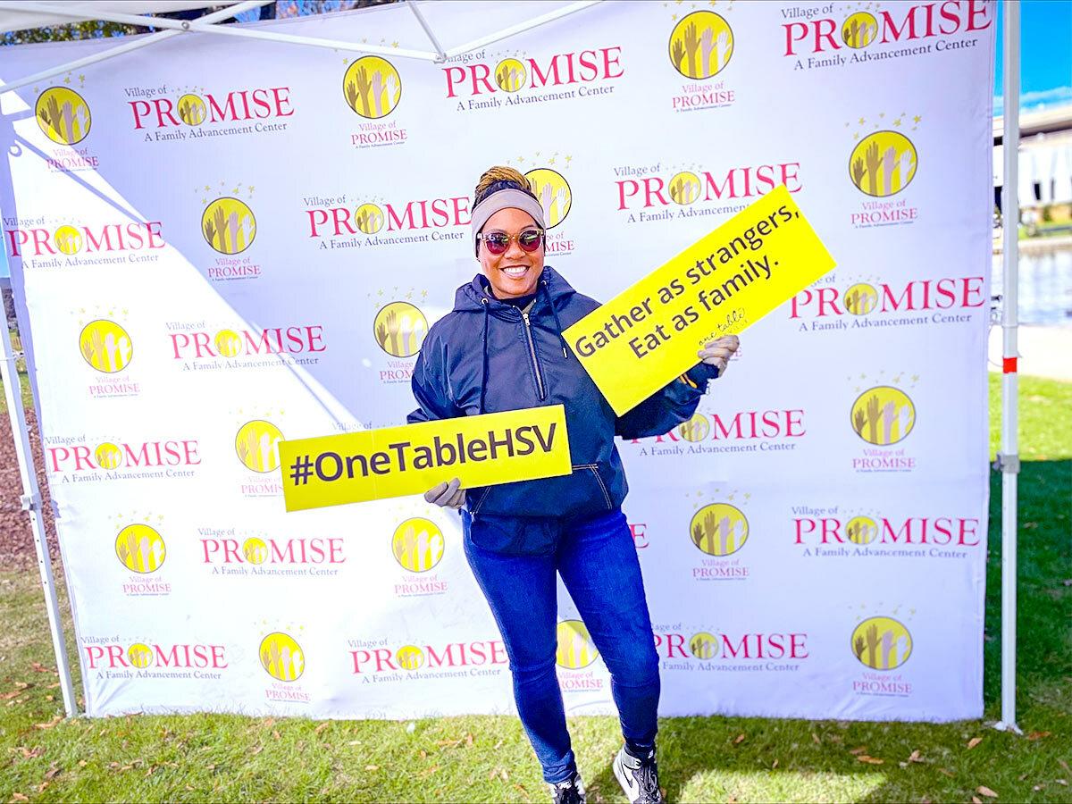 Floresha holding signs #OneTableHSV.