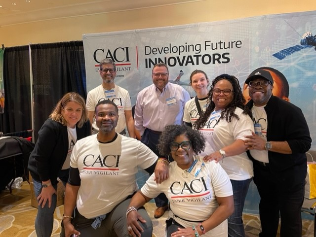 A group posed for the camera wearing matching CACI t-shirts.