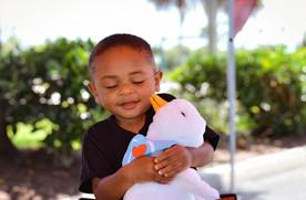 Gabe giving a big hug to his stuffed Aflac duck