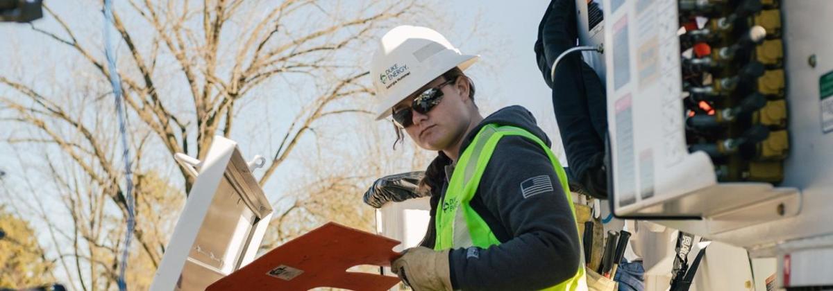 Georgia Hummel in safety wear, looking at a panel outside.