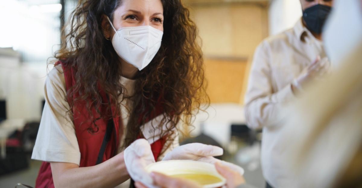 Woman in face mask serving food