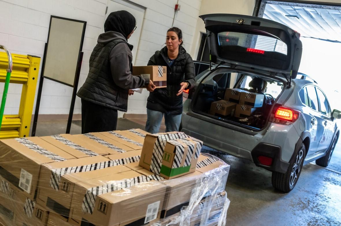 People loading boxes into a vehicle