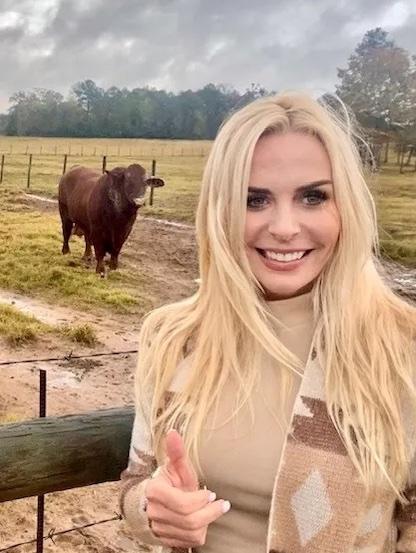 Mel Saettone on a farm with a cow in the background.