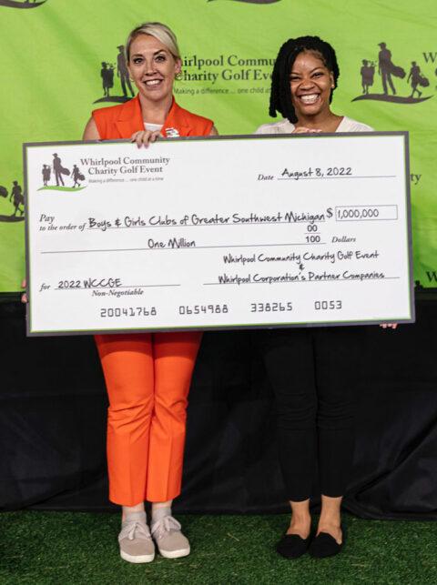 Two representatives from the boys and girls club pose with a large check