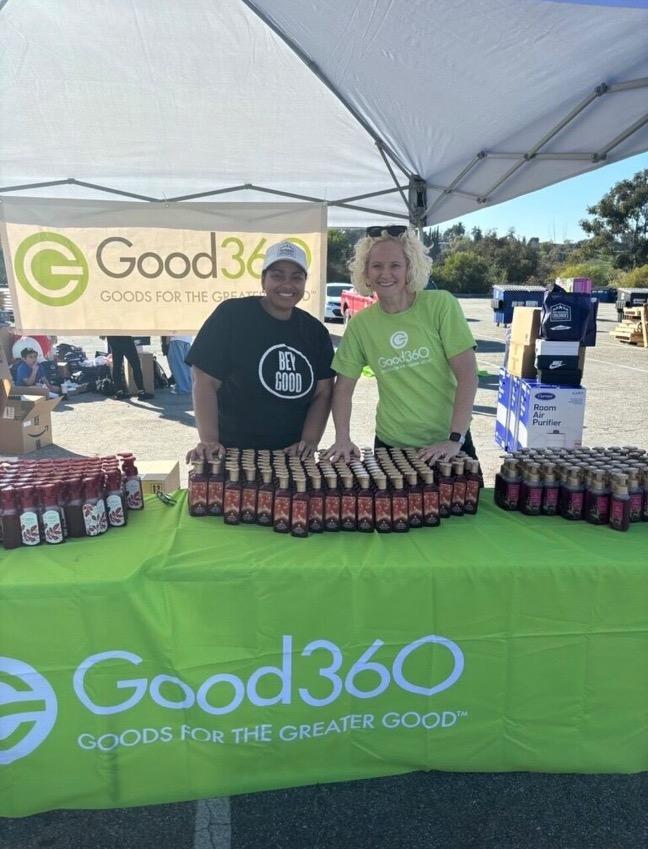 Two people standing at the Good360 booth