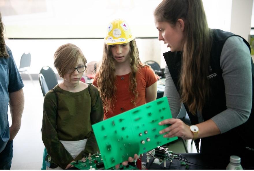 Grace Doepker showing a young children some equipment