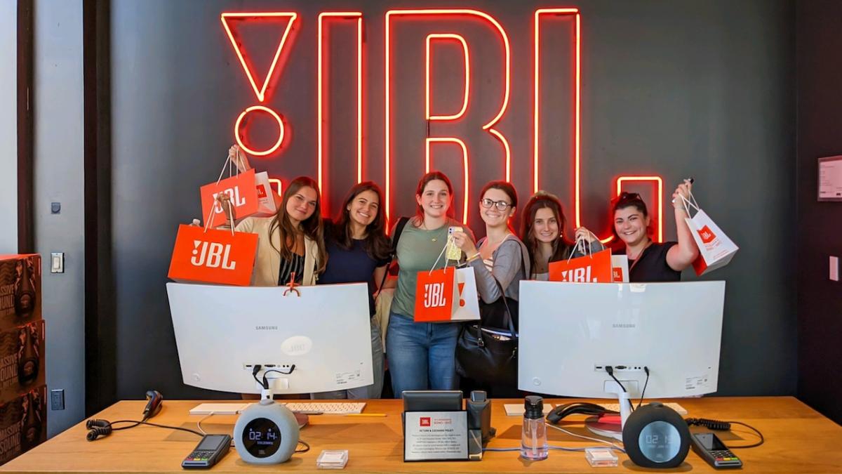 HARMAN interns posing in front of a JBL sign.