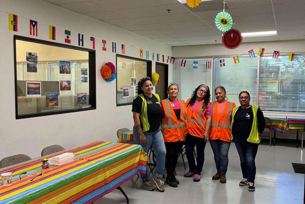 group of people wearing high-vis vests in a decorated break room