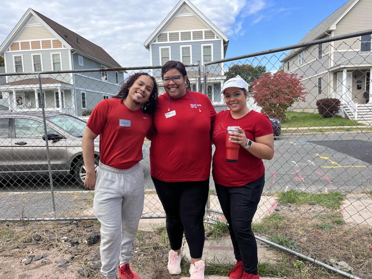 Three KeyBank volunteers shown outside of the new home.