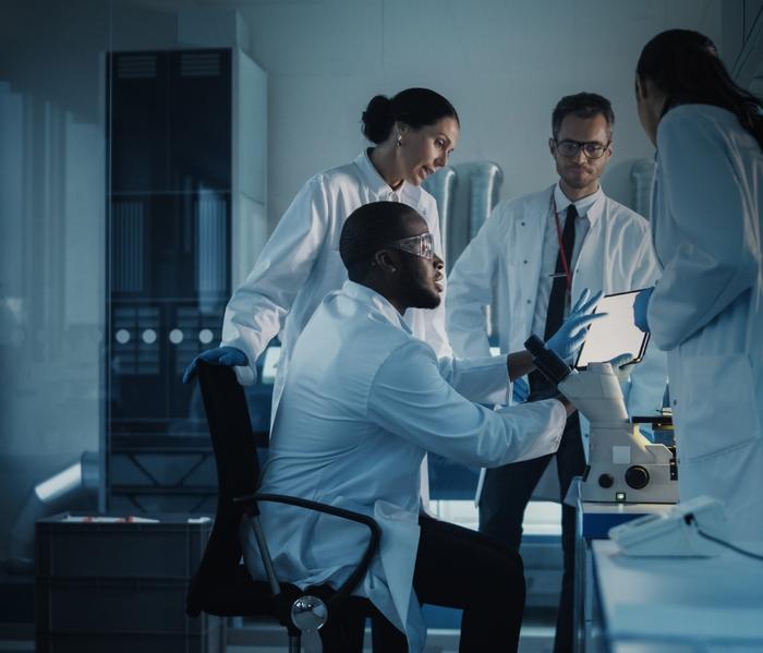 Group of four scientists working at a table.