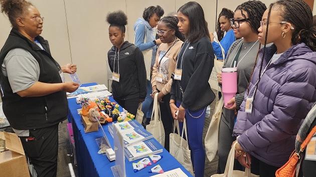 A group of students stood at an event stand 