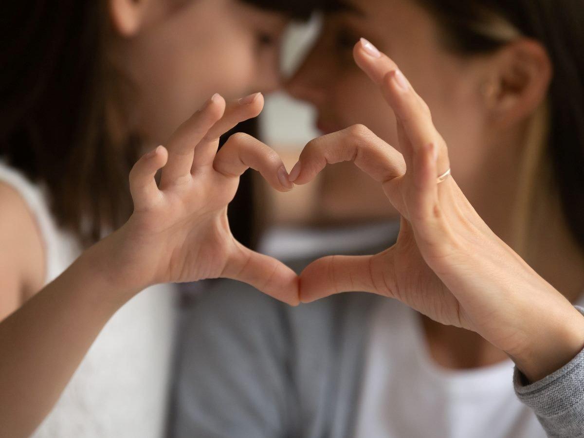 Parent and child making heart shape with hands