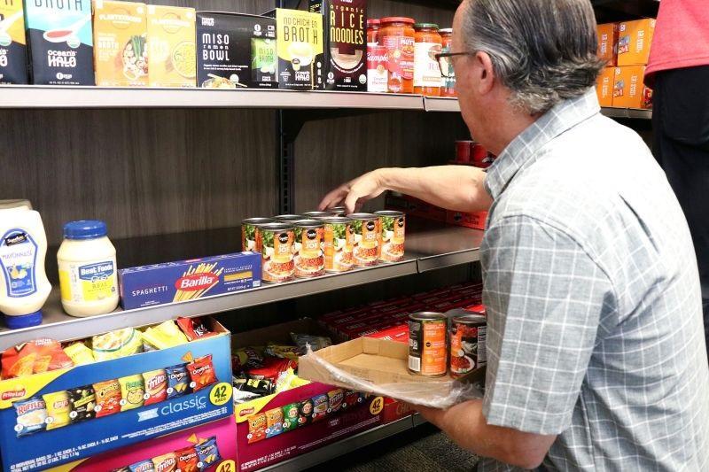 Person stocking cans in food pantry