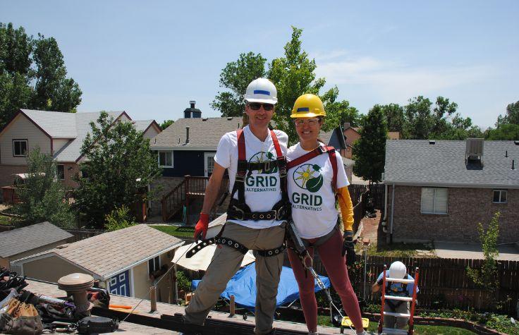 Workers installing solar panels on a roof.