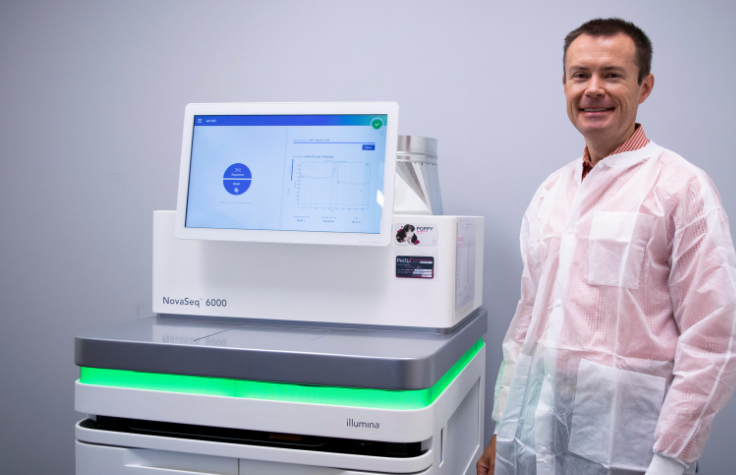 Daniel with the Illumina NovaSeq 6000, nicknamed "PoppySeq" at the PetDx offices.