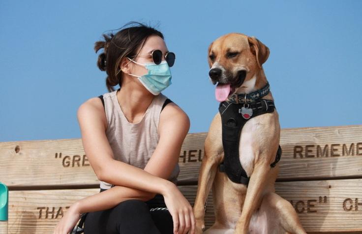 Rachel and her dog seated on a bench.