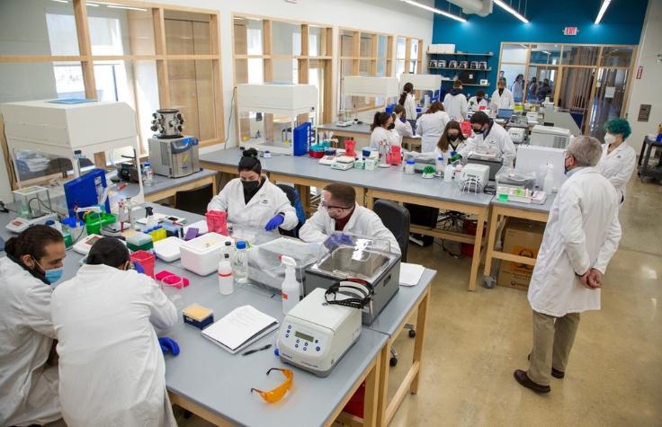 Gloucester Biotechnology Academy volunteer and retired biotechnology professional, Joseph Rosa, PhD, supervises students in the new biomanufacturing learning environment, built in 2021.