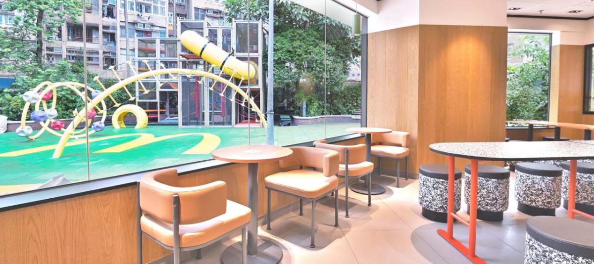 Inside of a McDonald’s restaurant with a window looking out on to an outdoor play area 