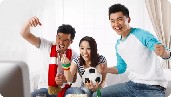 3 people celebrating while watching sports at home