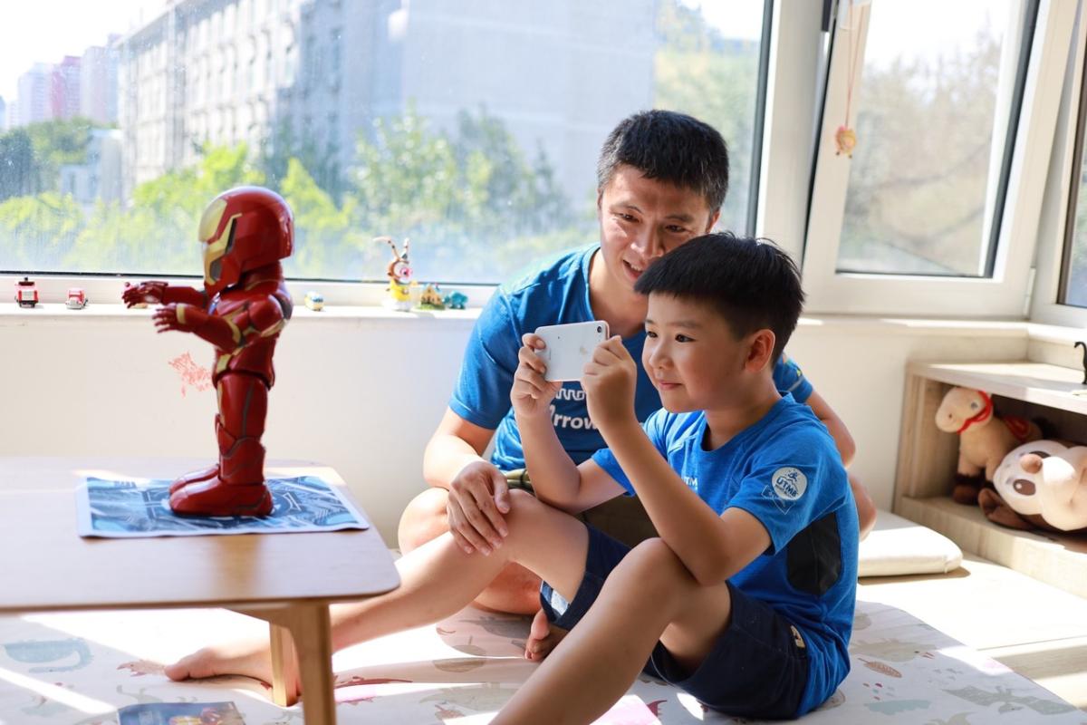 child and parent using a robot through a mobile device