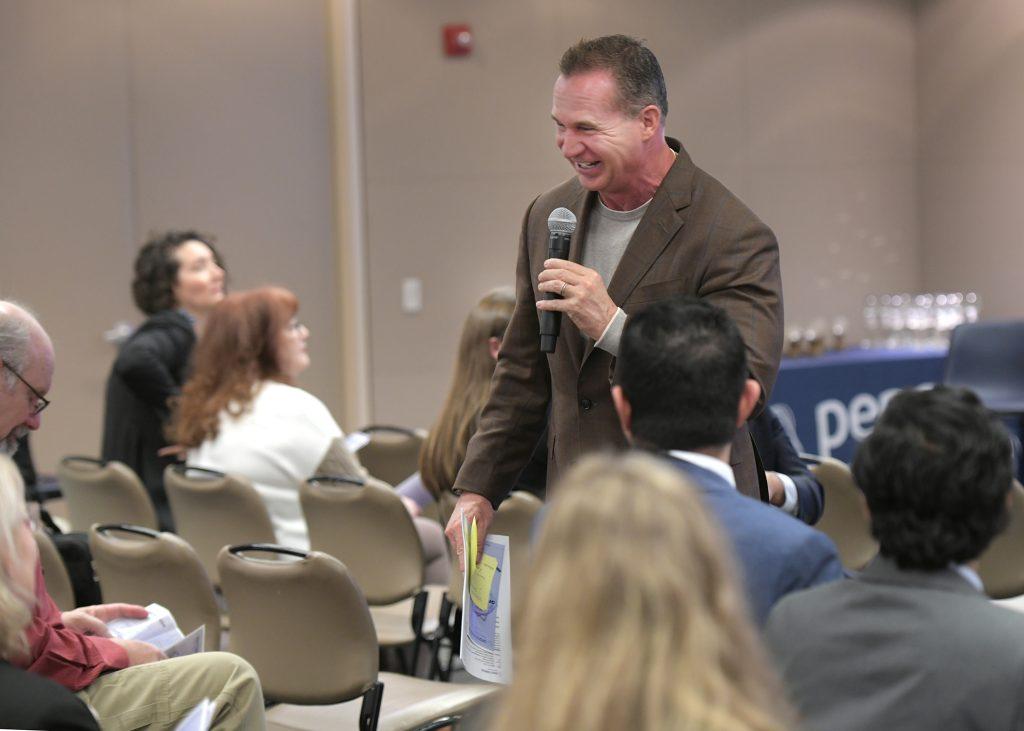 A person talking in front of an audience 