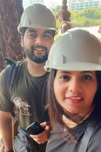 Jai shown with his wife and both are wearing hardhats.