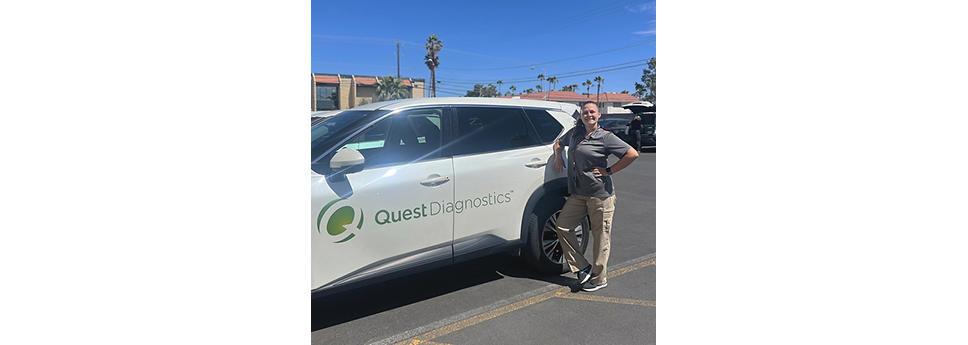 Jamie Croft standing next to a vehicle with Quest Diagnostics logo on the side.