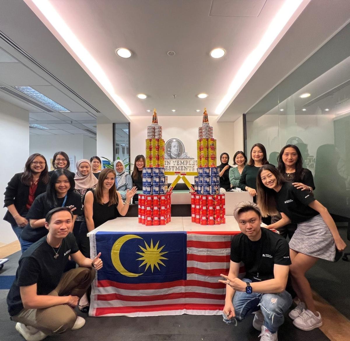 Group posing by two pyramids of cans