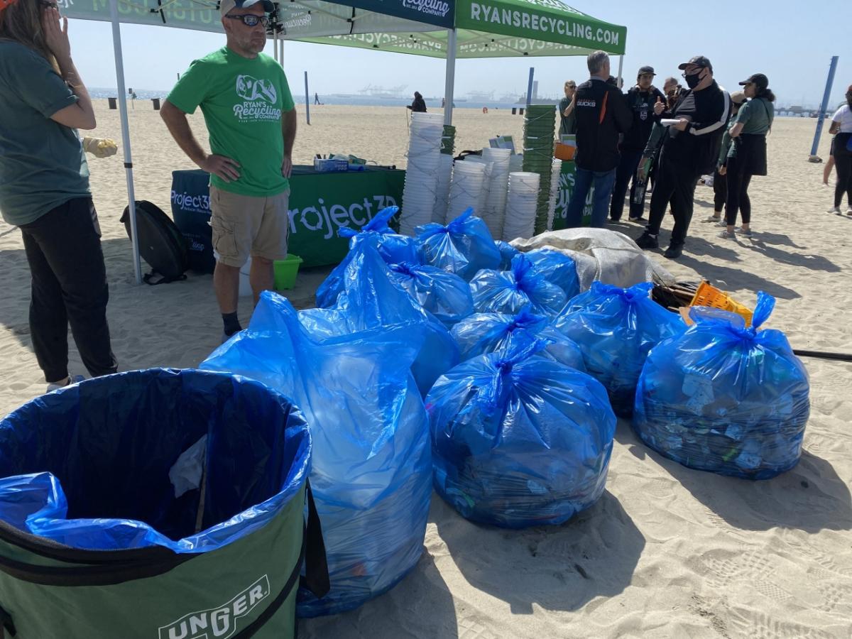 people picking up trash along a beach