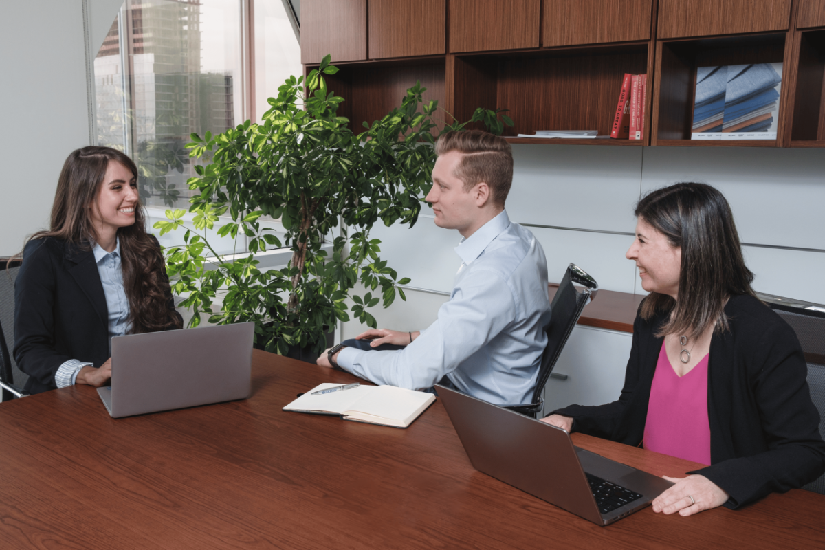 Three Gildan employees sitting around a conference table in an office