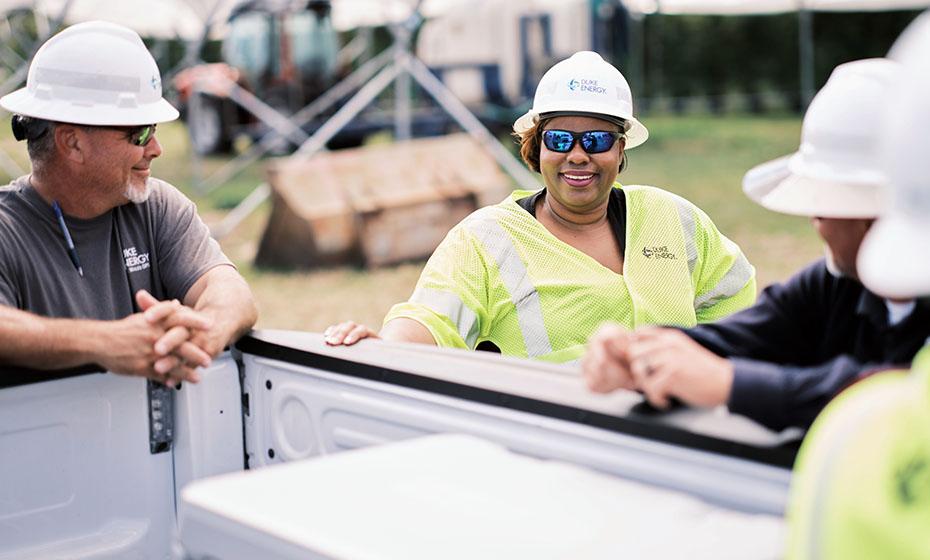 LaQuitta Ghent and others around the bed of a truck, smiling.