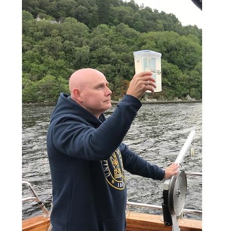 Neil Gemmell inspects a collected water sample aboard the Deepscan. | Photo by Ellie Rowley