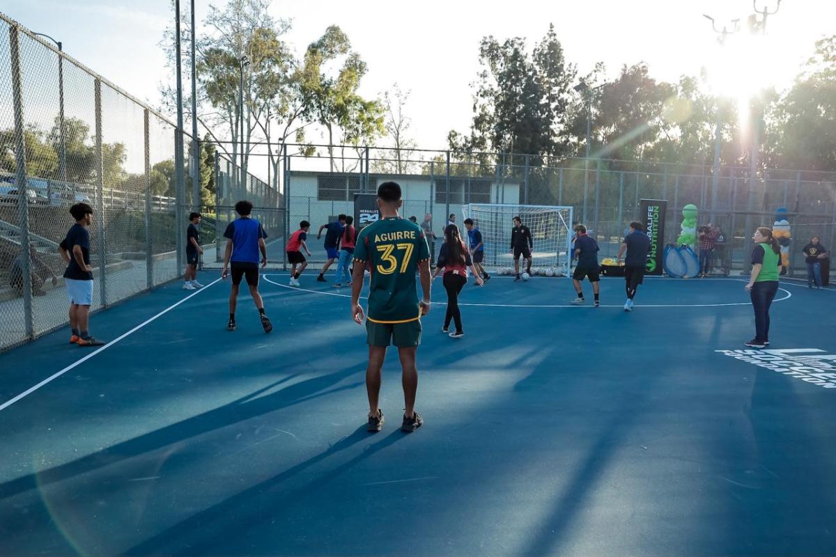 LA Galaxy's Daniel Aguirre watches children play at the new Long Beach mini-pitch fields installed earlier this year by AEG's LA Galaxy Foundation, Herbalife, and the U.S. Soccer Foundation.