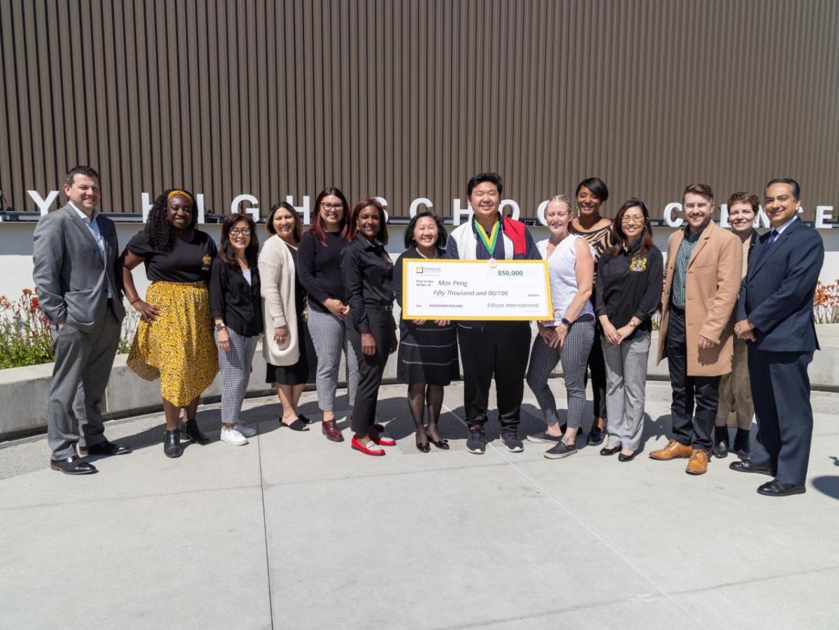 Max Peng with a group of others, holding a large check.