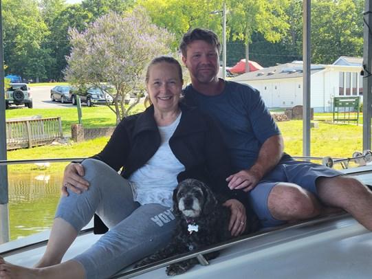 Two people smiling with dog